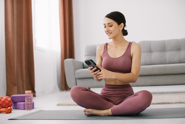 Jolie jeune femme regardant une vidéo de sport au téléphone