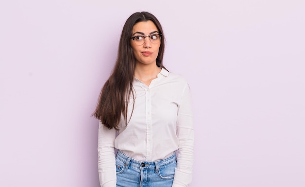 Jolie jeune femme se demandant, pensant à des pensées et des idées heureuses, rêvassant, cherchant à copier l'espace sur le côté