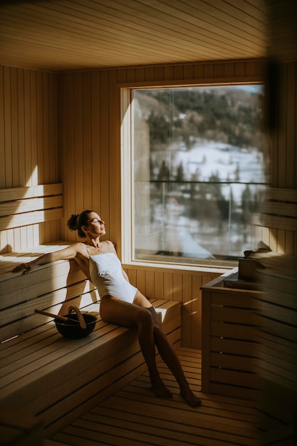 Jolie jeune femme se détendre dans le sauna