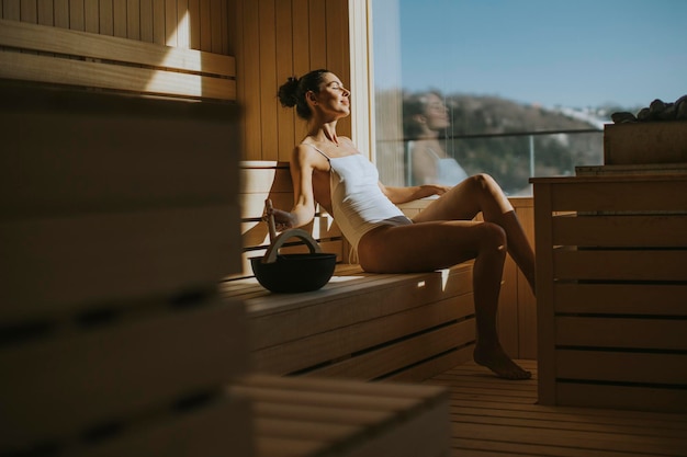 Jolie jeune femme se détendre dans le sauna