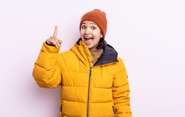 Jolie jeune femme se sentant comme un génie heureux et excité après avoir réalisé une idée. concept de temps froid