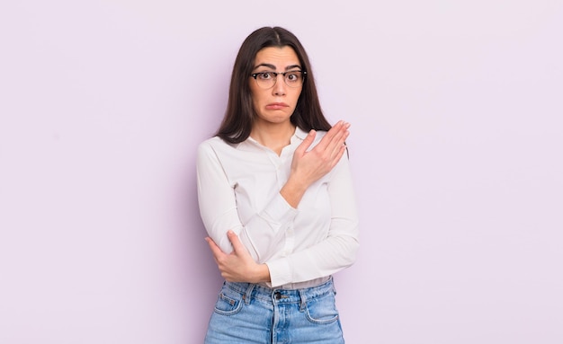 Jolie jeune femme se sentant confuse et désemparée, s'interrogeant sur une explication ou une pensée douteuse