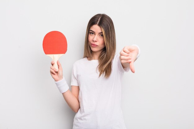 Jolie jeune femme se sentant croisée les pouces vers le bas concept de ping-pong