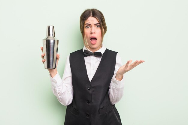 Jolie jeune femme se sentant extrêmement choquée et surprise. concept de barman à cocktails