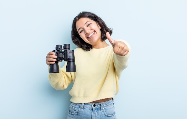 Jolie jeune femme se sentant fière, souriant positivement avec les pouces vers le haut. notion de jumelles