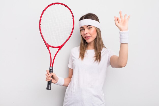 Jolie jeune femme se sentant heureuse, montrant son approbation avec un geste correct. notion de tennis