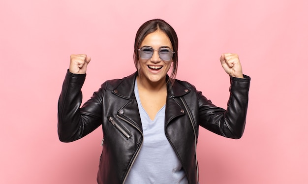 Jolie jeune femme se sentant heureuse, positive et réussie, célébrant la victoire, les réalisations ou la bonne chance