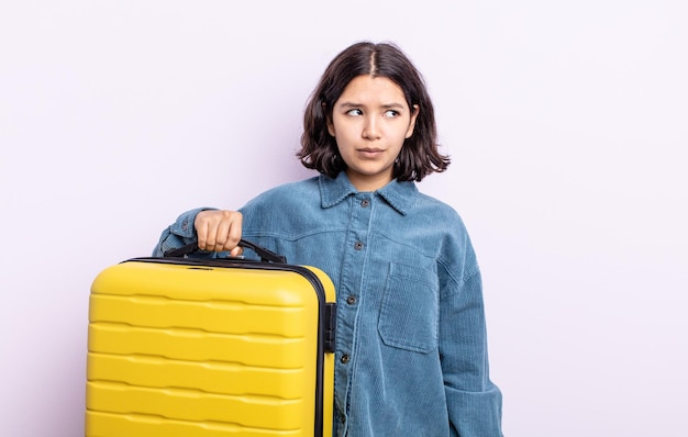 Jolie jeune femme se sentant triste bouleversée ou en colère et regardant vers le concept de cas de voyage latéral