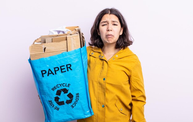 Jolie jeune femme se sentant triste et geignarde avec un regard malheureux et pleurant. concept de recyclage du papier