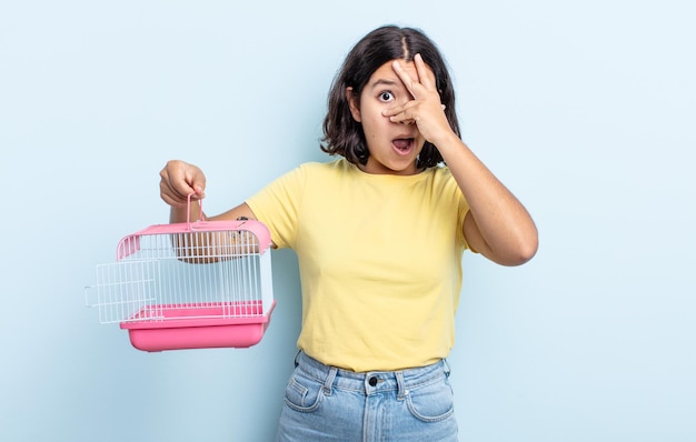 Jolie jeune femme semblant choquée, effrayée ou terrifiée, couvrant le visage avec la main. concept de cage pour animaux de compagnie