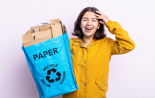 Jolie jeune femme semblant heureuse, étonnée et surprise. concept de recyclage du papier