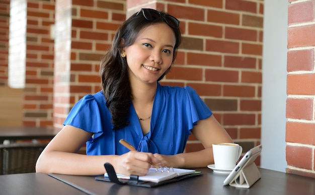 Jolie jeune femme souriante au café