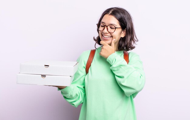 Jolie jeune femme souriante avec une expression heureuse et confiante avec la main sur le menton. concept à emporter