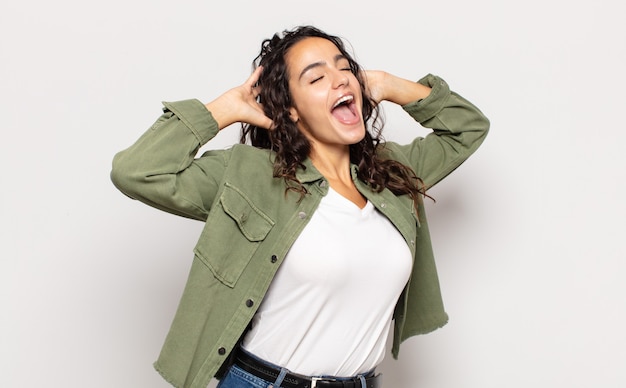 Jolie jeune femme souriante et se sentant détendue, satisfaite et insouciante, riant positivement et effrayante