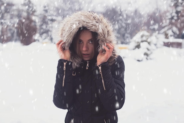 Jolie jeune femme sous les flocons en hiver