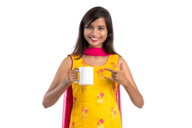 Jolie jeune femme avec une tasse de thé ou de café posant