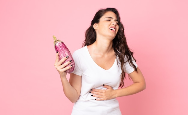 Jolie jeune femme tenant une aubergine