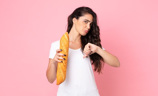 Jolie jeune femme tenant une baguette de pain