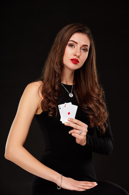 Jolie jeune femme tenant la combinaison gagnante de cartes de poker