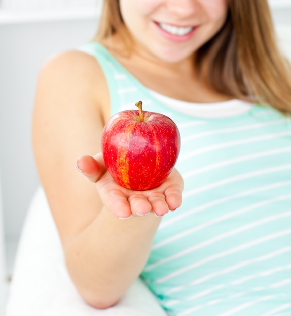 Jolie jeune femme tenant une pomme dans sa main