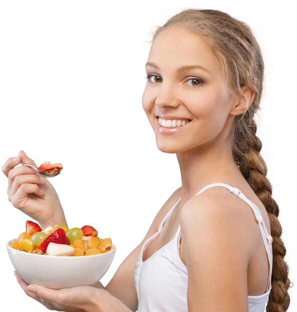 Jolie jeune femme tenant une salade et souriant à la caméra