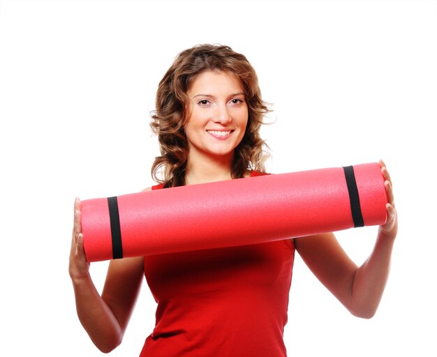 Une jolie jeune femme tenant un tapis rouge sur fond blanc