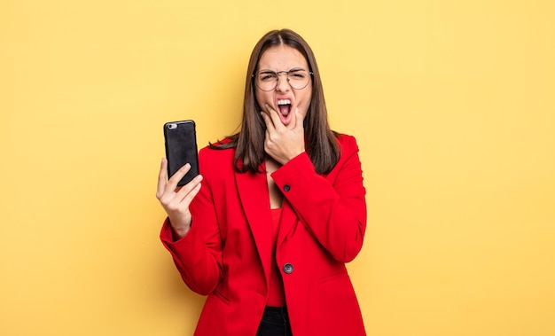 jolie jeune femme tenant un téléphone intelligent