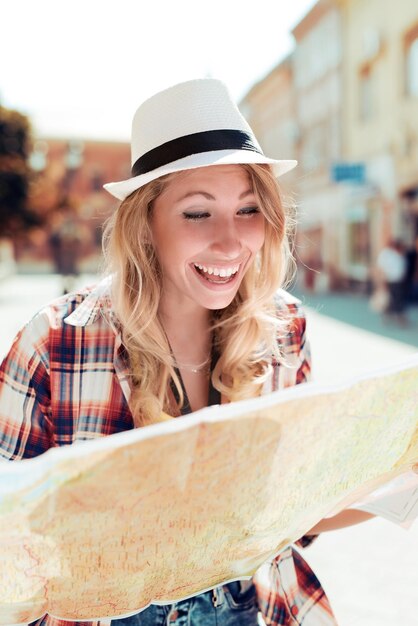 Photo jolie jeune femme touriste étudiant une carte