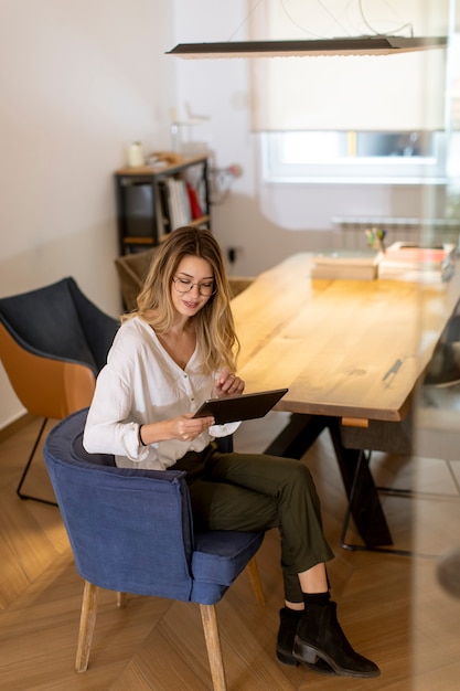 Jolie jeune femme travaillant avec une tablette numérique au bureau