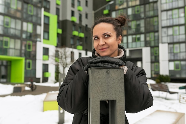 Une jolie jeune femme en vêtements d'hiver se promène dans la cour en hiver