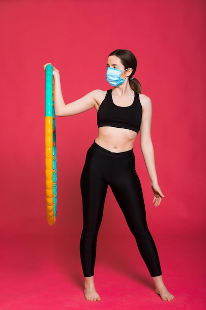 jolie jeune femme en vêtements de sport étirant les muscles avant de s'entraîner sur le rouge