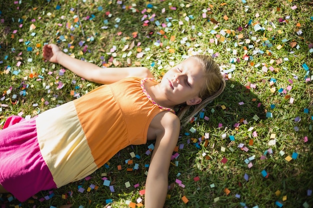 Photo jolie jeune fille allongée sur l'herbe dans le parc