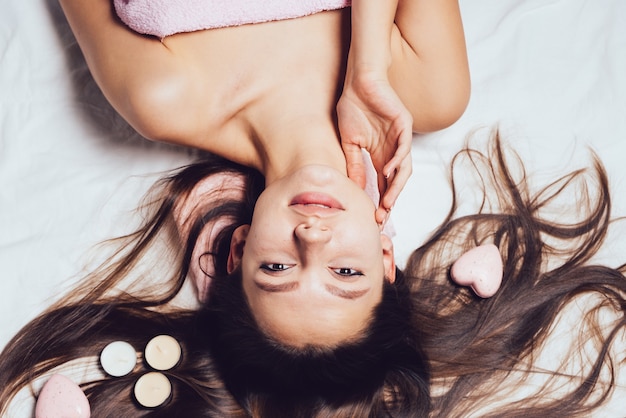 Jolie jeune fille aux cheveux longs bénéficiant de soins de spa