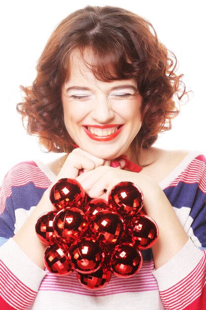 Jolie jeune fille avec des boules de Noël rouges