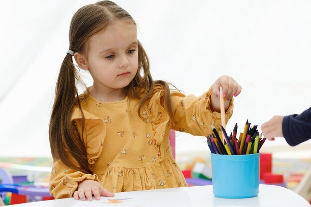 Jolie jeune fille européenne enfant peinture avec un crayon de couleur Concept d'éducation des enfants de la maternelle