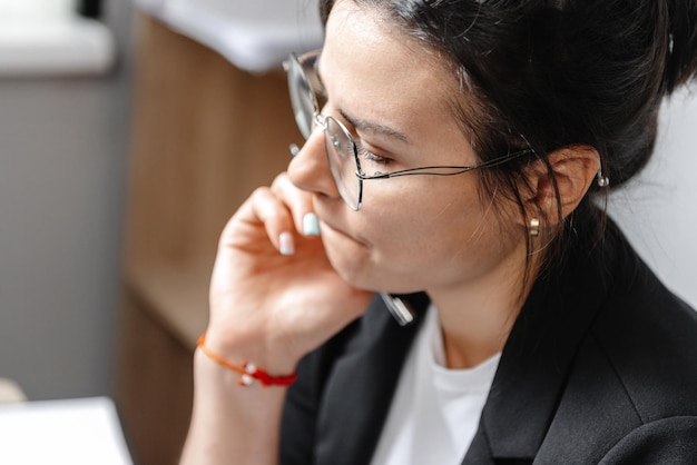 D'une jolie jeune fille pensante une fille travaillant à la maison et pensant à un article gros plan portrai