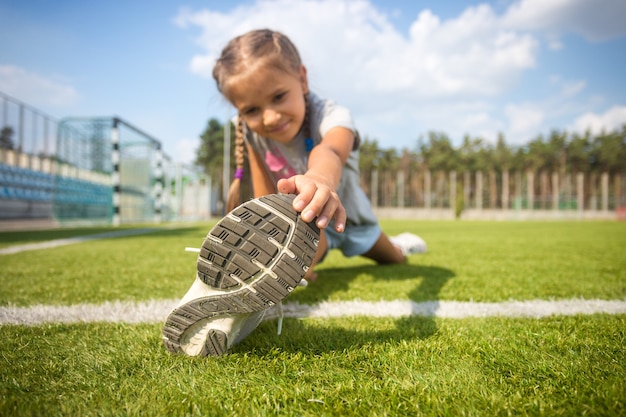 Jolie jeune fille qui s'étend sur l'herbe avant de courir