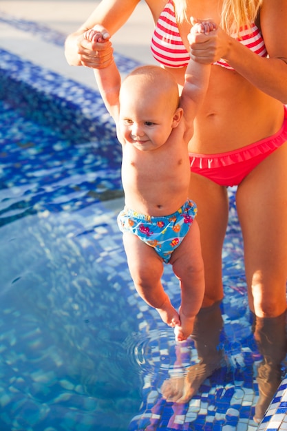 Jolie jeune maman avec bébé à la piscine