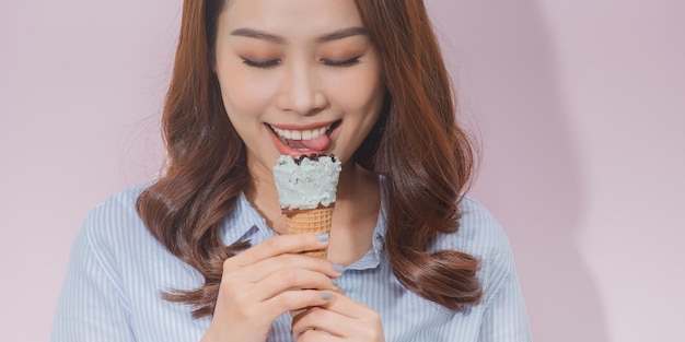 Jolie jeune mannequin mangeant un cornet de crème glacée