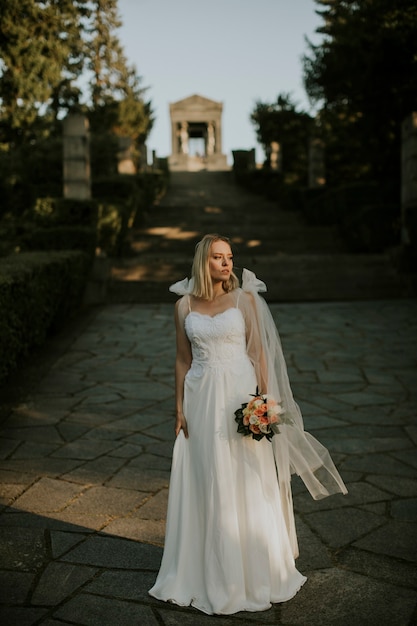 Jolie jeune mariée avec bouquet de fleurs