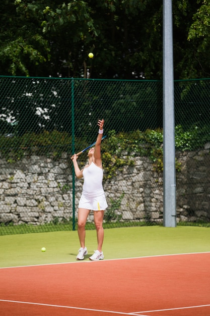 Jolie joueuse de tennis servant la balle