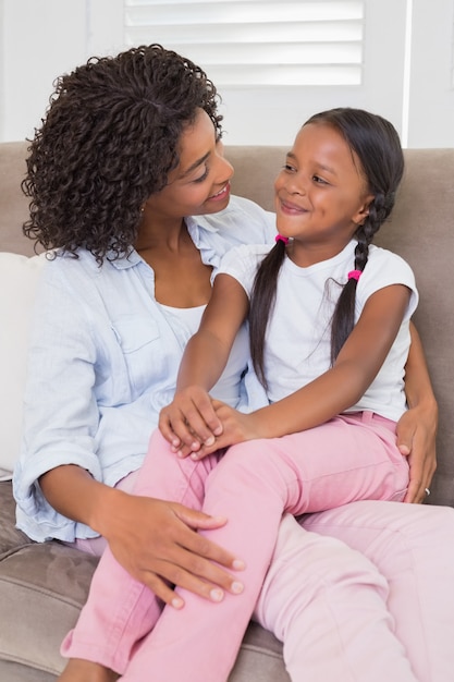 Jolie mère assise sur le canapé avec sa fille