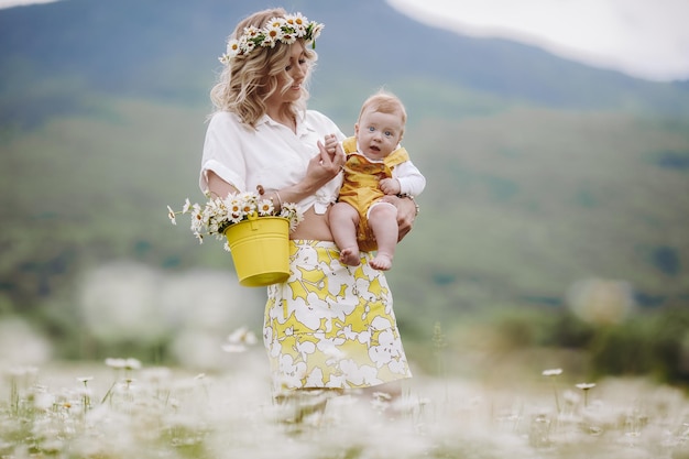 Jolie mère et bébé mignon dans le champ de camomille