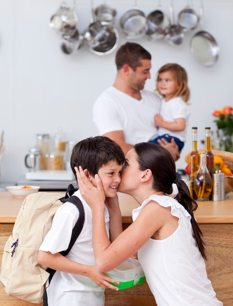 Jolie mère embrassant son fils avant l&#39;école