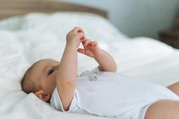 Jolie petite fille de 24 mois sur le lit avec des tons naturels de lin blanc mise au point sélective