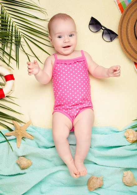 Jolie petite fille avec des accessoires de plage. Vacances en mer avec bébé, concept d'été