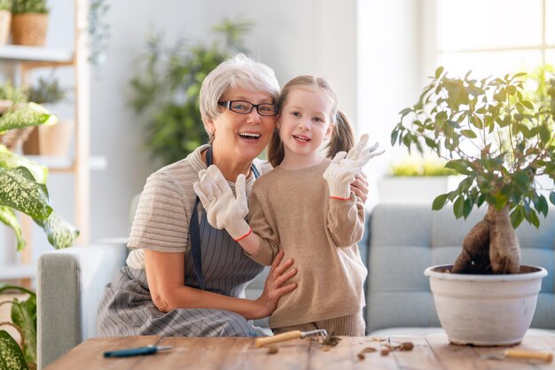 Jolie petite fille aidant sa grand-mère à s'occuper des plantes Mamie et sa petite-fille