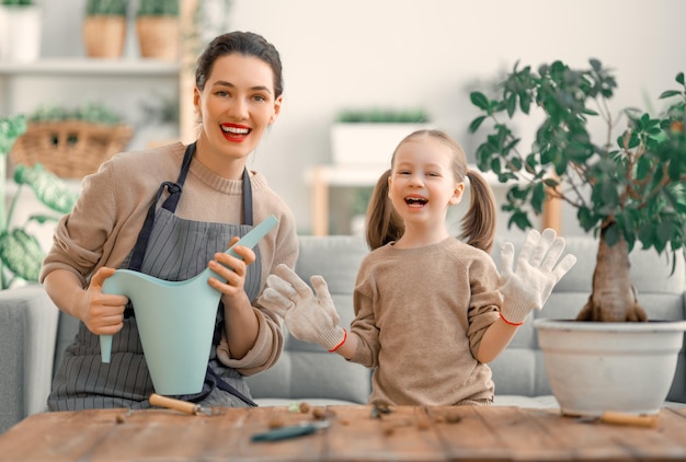 Jolie petite fille aidant sa mère à s'occuper des plantes Maman s'engageant dans le jardinage à la maison