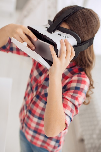 Photo jolie petite fille à l'aide d'un casque vr devant la caméra