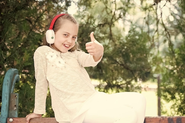 Jolie petite fille appréciant la musique à l'aide d'écouteurs